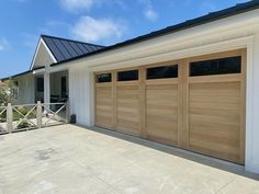 a white house with two wooden garage doors