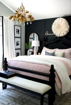 a bedroom decorated in black and white with pops of pink on the headboard, footstools, and bed