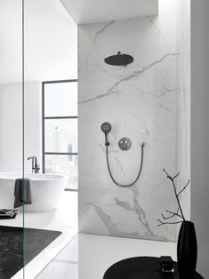 a modern bathroom with marble walls and flooring, including a bathtub in the corner