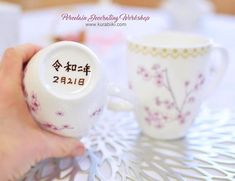 two coffee mugs with writing on them sitting on a table