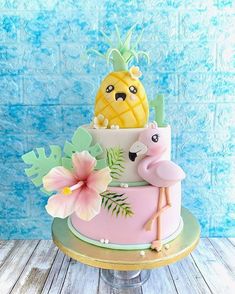 there is a pink cake with a pineapple on top and flamingos around it