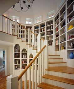 there is a staircase in the house with bookshelves