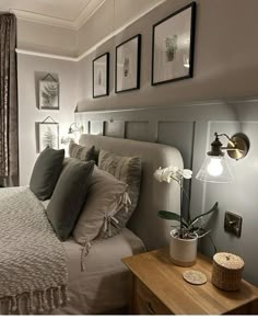 a bedroom with a bed, nightstand and pictures on the wall above it's headboard