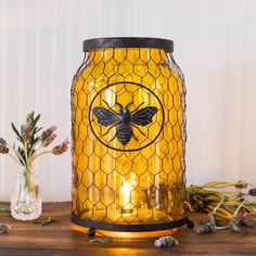 a yellow glass jar with a bee on it