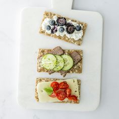 there are three different types of food on the cutting board, each with cheese and cucumbers