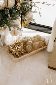 a tray filled with ornaments next to a christmas tree