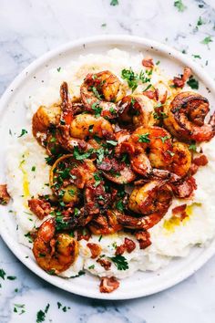 a white plate topped with mashed potatoes and shrimp