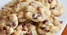 a white plate topped with cookies covered in cranberry filling on top of a wooden table