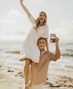 a man carrying a woman on his back while she holds her up in the air