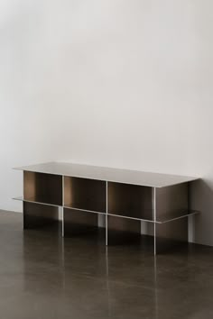 a metal shelf sitting on top of a floor next to a white wall with no one in it