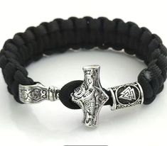 a black bracelet with a silver cross on it