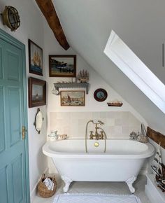 a bathroom with an old fashioned bathtub in the corner and pictures on the wall