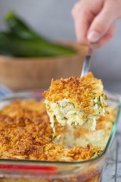 a person holding a spoon full of broccoli casserole