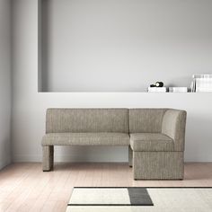 a couch sitting on top of a hard wood floor next to a white wall in a living room