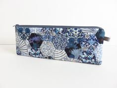 a blue and white flowered pouch with an animal design on the front, sitting on a white surface