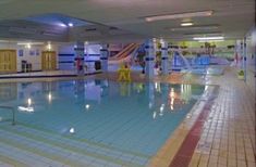 an indoor swimming pool with slides and water features