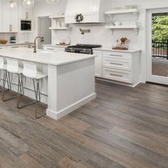 a large kitchen with white cabinets and counter tops