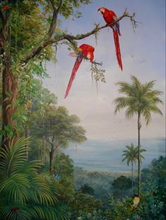 two red birds sitting on top of a tree branch in a forest filled with palm trees