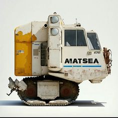 an old white and yellow construction vehicle sitting on top of it's back wheels