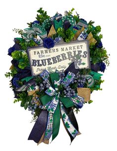 a blue and green wreath with the words farmers market on it, surrounded by greenery