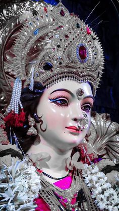 a close up of a woman wearing an elaborate headdress and jewelry on her face