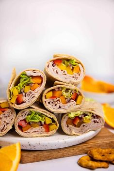 several wraps are stacked on top of each other with fruit and veggies in the wrapper