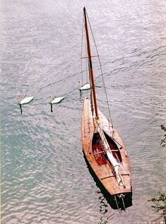 a sailboat floating on top of a body of water next to another boat in the ocean