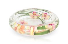 a glass bowl filled with flowers on top of a white table