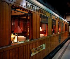 the inside of a train car that is on display in a museum like setting with wood paneling and windows