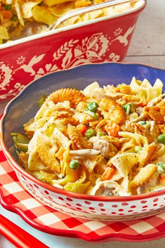 a bowl filled with pasta and vegetables on top of a red checkered table cloth