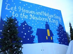 a man standing in front of a sign that says get heaven and nature sing to the newborn king