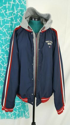 Tommy Hilfiger Jeans Windbreaker Jacket Size:XXL  Color: Blue, Grey Body: 100% Polyester Lining: 100% Polyester Hood: 75% Polyester 25% Cotton rn:77806 Jacket is accented with suede like fabric on the sleeve (twin stripes, red and white) Main body color is navy blue with a grey hood Hood has pull cords to tighten  Zipper has red and white teeth Snap Buttons have Tommy Jeans  Small flaw See Pictures for details Fast Shipping Recommendation: Please check out my other items/store. Si Hooded Outerwear With Button Closure For College, Varsity Hooded Sport Coat For Winter, Hooded College Windbreaker With Pockets, Hooded Snap Button Outerwear For Streetwear, Hooded Varsity Sport Coat For Winter, Winter Varsity Hooded Sport Coat, Hooded Windbreaker With Pockets For College, Winter Hooded Varsity Sport Coat, Hooded Winter Sport Coat For College