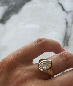 a person's hand with a gold ring on it and a diamond in the middle