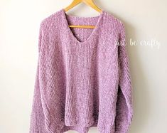 a purple sweater hanging on a hanger