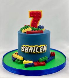 a birthday cake made to look like a train with the number seven on it and legos