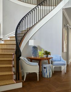 there is a table and two chairs in the room next to the stair case on the floor