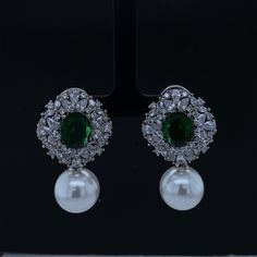 Elevate your elegance with our Gold Plated CZ Victorian Design Earrings. Inspired by the intricate beauty of the Victorian era, these earrings feature dazzling cubic zirconia (CZ) diamonds that sparkle with a timeless allure. A delicate pearl dangles below, adding a touch of sophistication and movement. The regal emerald gemstone accentuates the design, infusing a rich burst of color. These exquisite gemstone earrings are a perfect choice for brides seeking a touch of vintage charm or anyone des Victorian Pearl Earrings, Elegant Cubic Zirconia Earrings With Stone Setting, Exquisite Green Diamond Wedding Earrings, Exquisite Green Diamond Earrings For Wedding, Bridal Cubic Zirconia Earrings For Celebration, Bridal Earrings With Matching Cubic Zirconia For Celebration, Elegant Bridal Earrings With Stone Setting, Party Earrings With Cubic Zirconia Stone Setting, Green Teardrop Pearl Earrings For Wedding