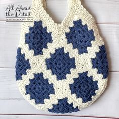 a crocheted bag hanging from a hook on a white wooden background with the words all about the details written below it