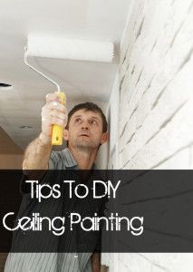 a man is painting the ceiling with white paint