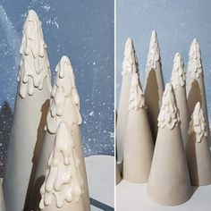 there are several white christmas trees on the table and one is made out of clay