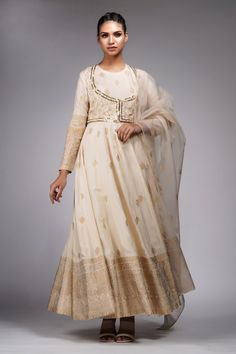 Off white full sleeve anarkali crafted in silk base with golden leaf hand bock print motifs. Paired with a coordinating churidar and dupatta. Comes along with a floral hand block print jacket.
Components: 4
Pattern: Hand-Block Print
Type Of Work: Leaf, Floral
Neckline: Round Neck
Sleeve Type: Full Sleeves
Fabric:  Anarkali: Silk, Churidar : Shantoon, Dupatta: Organza
Color: Off White
Other Details: 
Anarkali:
Broad mandala print border
Jacket:
Sequin and cutdana embellished border
Dupatta:
Leaf Organza Anarkali Dress, Block Print Anarkali, Anarkali Bridal, White Anarkali Suits, Off White Anarkali, Anarkali Tops, Anarkali Designs, Suit With Jacket, White Anarkali