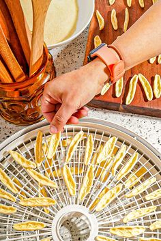 a person reaching for some kind of food on a table with utensils in it