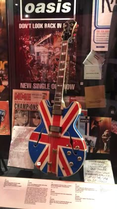 an electric guitar with the british flag on it's neck is in a display case