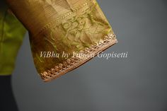 Olive Green Copper Zari Kanchi Silk Saree and blouse. This saree is an especially luxurious choice, crafted from Kanchi silk with shimmering olive green and copper zari weave. Its beautiful color and texture provide a unique, elegant look that will instantly elevate any ensemble. The accompanying saree blouse is tailored and embellished with embroidered neckline and also back with handcrafted dori and tassels. The attention to detail further enhances it and gives the blouse a great finish.. Ceremonial Blouse Piece In Gold With Self Design, Ceremonial Gold Blouse Piece With Self Design, Elegant Gold Tussar Silk Blouse, Gold Designer Saree In Traditional Drape, Designer Gold Saree With Zari Work, Elegant Ceremonial Blouse Piece With Self Design, Elegant Ceremonial Saree Blouse Piece, Gold Tissue Silk Blouse With Zari Weaving, Elegant Ceremonial Kurta With Zari Weaving