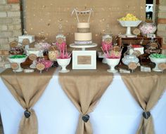 a table topped with lots of desserts and candies covered in burlap