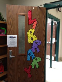 a door decorated with the words happy birthday and letters that spell out, in front of a bookcase