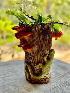 a vase with plants in it sitting on a table