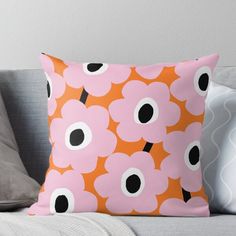 an orange and pink pillow with black dots on it