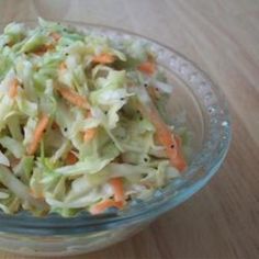 a glass bowl filled with coleslaw and carrots