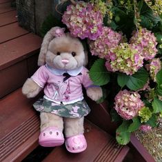 Build a bear vanilla fudge bunny wearing a cute outfit sitting on some stairs and flowers behind her Plushie Photography, Kawaii Bears, Teddy Outfit, Boys Easter Basket, Totes Ideas